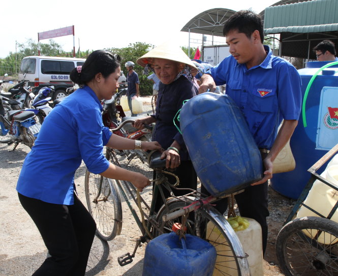 Giúp bà Bùi Thị Nga chở nước ngọt về nhà - Ảnh: Vân Trường