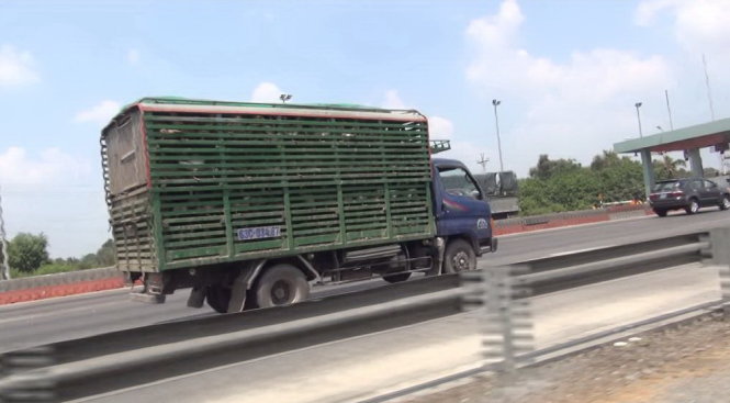 Một chiếc xe tải được ngăn thành nhiều tầng, chở hàng ngàn con vịt chạy vào đường cao tốc TP.HCM - Trung Lương - Ảnh: Mậu Trường