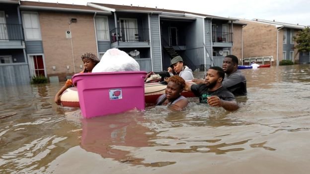 Người dân một khu chung cư ở Houston sơ tán khi nước lũ dâng - Ảnh: AP