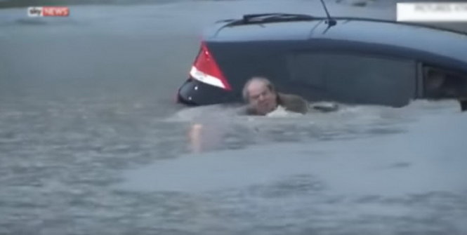 Một người đàn ông kịp thoát ra ngoài trước khi ô tô bị chìm trong nước lũ - Ảnh chụp từ video clip