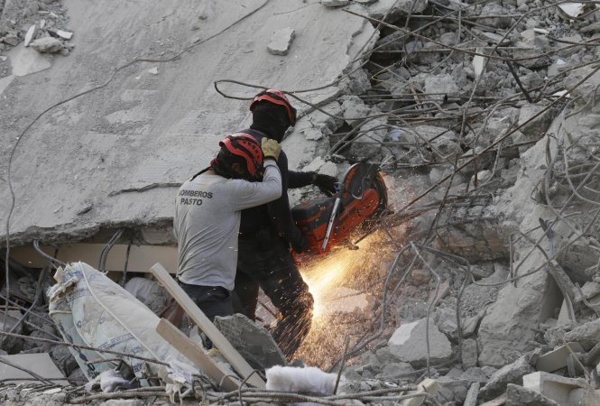 Nhân viên cứu hộ làm việc ngày đêm để tìm kiếm người còn bị kẹt dưới đống đổ nát. Ảnh: Reuters