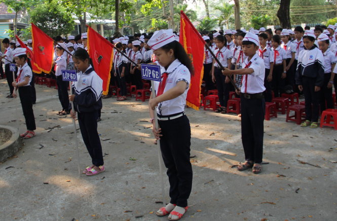 Học sinh Trường THCS Nghĩa Hà cúi đầu mặc niệm những người bạn xấu số - Ảnh: Tr.Mai