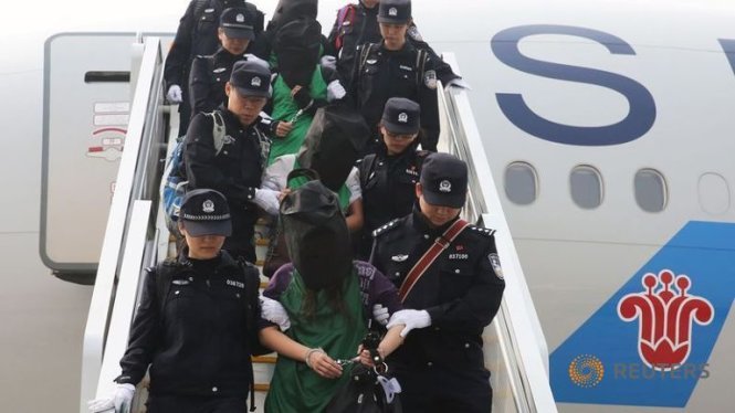 Cảnh sát dẫn giải nhóm người Đài Loan bị Kenya trục xuất về Trung Quốc - Ảnh:Reuters