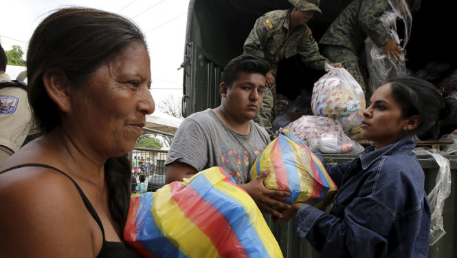 Một nạn nhân động đất tại Ecuador nhận đồ cứu trợ - Ảnh: Reuters