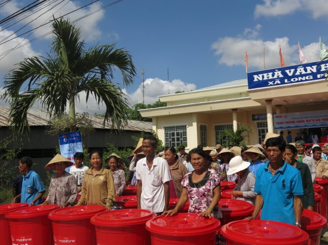 Người dân xã Long Phú vui mừng khi nhận thùng trữ nước - Ảnh: T.Trang