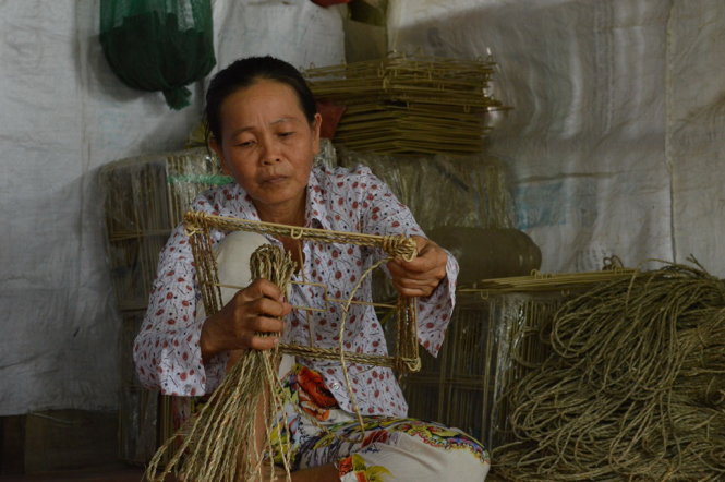 Bà Nguyễn Thị Tốt chắt chiu từng đồng từ công việc đan thảm - Ảnh: Thúy Hằng