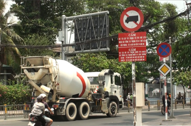 Một xe bồn của Công ty Holcim vẫn chạy vào đường có biển cấm xe tải lưu thông từ 6g - 24g trên đường Nơ Trang Long (TP.HCM) để đổ bêtông cho một công trình dân dụng 
- Ảnh: Hoàng Lộc