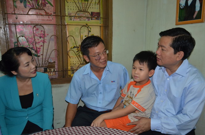 Ông Đinh La Thăng thăm công nhân Võ Chí Trung (trái) bị tai nạn lao động, sáng 23-4 - Ảnh: Vũ Thủy