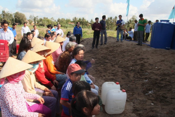 Từ sáng sớm, nghe tin có máy chuyển hòa nước mặn thành nước ngọt để cung cấp miễn phí cho người dân, bà con đến địa điểm đặt máy từ rất sớm để hứng nước về xài - Ảnh: Mậu Trường