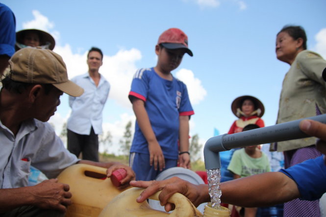 Người dân rất phấn khởi vì từ nay đã có nguồn nước ngọt miễn phí để sử dụng - Ảnh: Mậu Trường