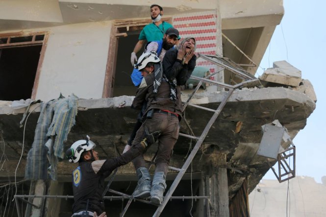 Các tình nguyện viên ở Syria cứu người dân ra khỏi một tòa nhà đổ nát tại Aleppo - Ảnh: AFP