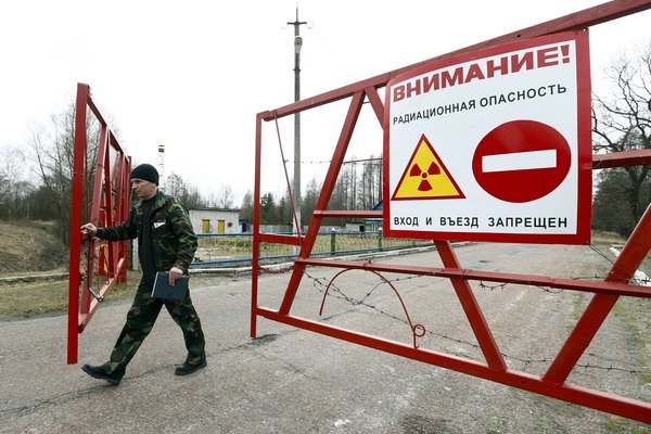 Một nhân viên bảo vệ mở cánh cổng ở chốt kiểm soát Maidan tại khu vực cấm bao quanh khu nhà máy điện hạt nhân Chernobyl - Ảnh: CS Monitor