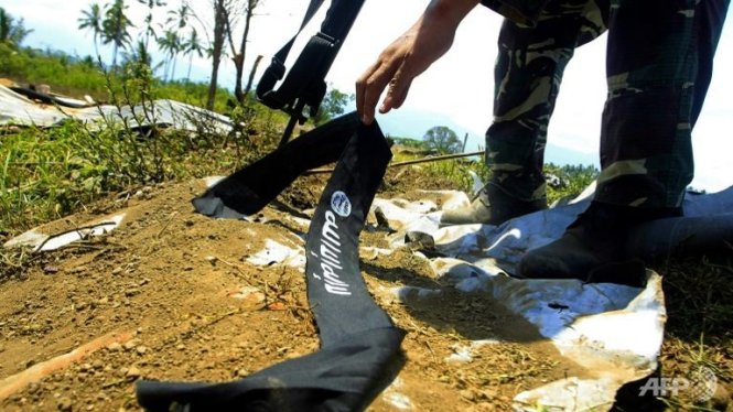 Một binh sĩ Philippines nhặt dải băng cột đầu của một phiến quân Hồi giáo bỏ lại thị trấn Butig - Ảnh:AFP