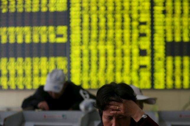Các nhà đầu tư đang xem xét thông tin tại một sàn giao dịch chứng khóa ở tỉnh Giang Tô, Trung Quốc - Ảnh: Reuters