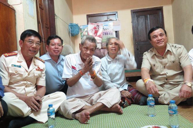 Đoàn cán bộ tỉnh Quảng Nam đến thăm ông Lê Việt Muồn (ngồi giữa) tại nhà riêng của ông ở tỉnh Sê Kông hôm 11-4 - Ảnh: Tấn Vũ