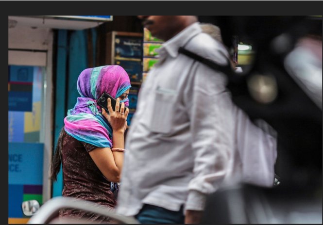Một phụ nữ đang nói chuyện điện thoại ở Mumbai - Ảnh: Bloomberg