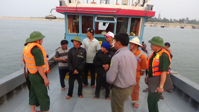 Bộ đội biên phòng Quảng Bình giải thích với người dân xã Kỳ Lợi về tác hại của cá chết - Ảnh: Đức Trí