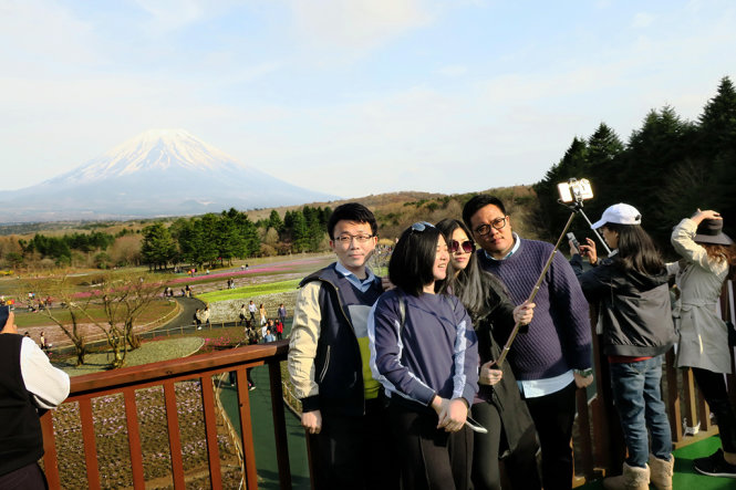 Một nhóm bạn trẻ selfie tại công viên ở Motosu với hậu cảnh là núi Phú Sĩ - Ảnh: TTD