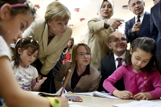 Thủ tướng Đức Angela Merkel (thứ ba từ trái sang) đến thăm một điểm giữ trẻ trong trại tị nạn Nizip ở Thổ Nhĩ Kỳ ngày 23-4 - Ảnh: Reuters