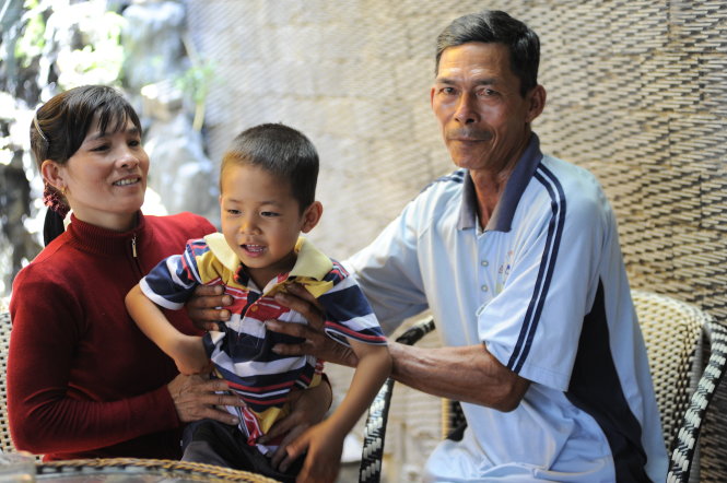Ông Đinh Ngọc Tân với con gái nuôi Đinh Thị Huyền và đứa trẻ ra đời trong hòa bình - Ảnh: Tự Trung