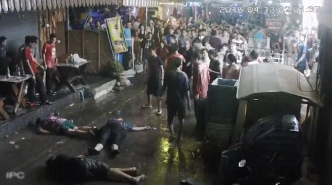 Ba du khách bị đánh nằm bất tỉnh dưới đất - Ảnh chụp từ video clip