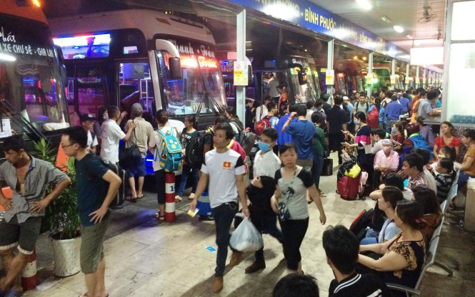 Hàng trăm người xếp hàng mua vé và đợi xe trong các khu vực nhà chờ của bến xe Miền Đông - Ảnh: Lê Phan