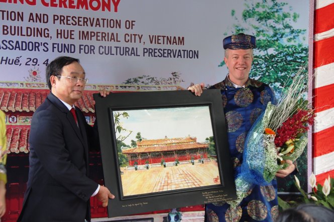 Ông Nguyễn Văn Cao, chủ tịch UBND tỉnh Thừa Thiên - Huế trao quà lưu niệm là bức tranh Triệu Tổ Miếu được chế tác bằng pháp lam cho đại sứ Hoa Kỳ Ted Osius - Ảnh: MINH AN