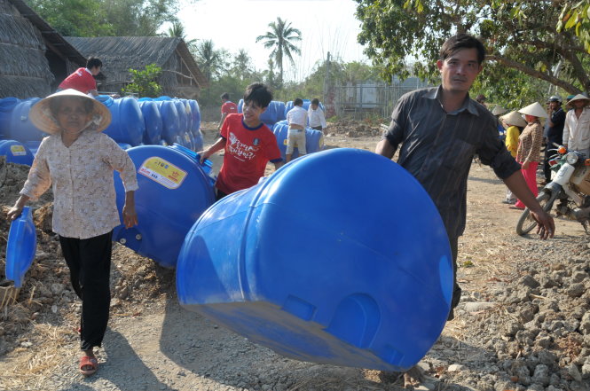 Người dân xã An Hiệp, huyện Ba Tri (Bến Tre) nhận bồn chứa nước từ chương trình “Nước cho vùng hạn, mặn” - Ảnh: Thanh Tú