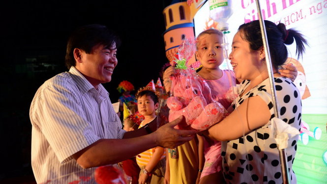 Ông Tăng Hữu Phong - tổng biên tập báo Tuổi Trẻ - tặng quà cho các bé có sinh nhật tháng 4 - Ảnh: Quang Định