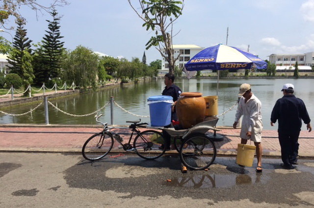 Người dân đưa dụng xô, kiệu vào tận nhà máy để chở nước về dùng - Ảnh: N. Triều