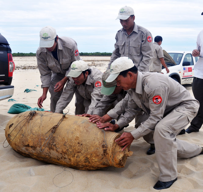 Nhân viên của Tổ chức Cây Hòa Bình (Peace Tree) chuẩn bị hủy nổ một quả bom 1.000 cân Anh được chuyên chở hơn 100km từ tây Hướng Hóa về bãi hủy miền duyên hải -Lê Đức Dục
