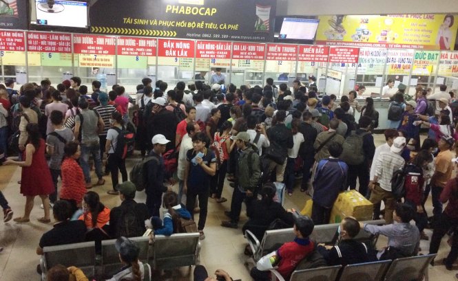 Hàng trăm người xếp hàng mua vé và đợi xe trong các khu vực nhà chờ của bến xe Miền Đông - Ảnh: Lê Phan
