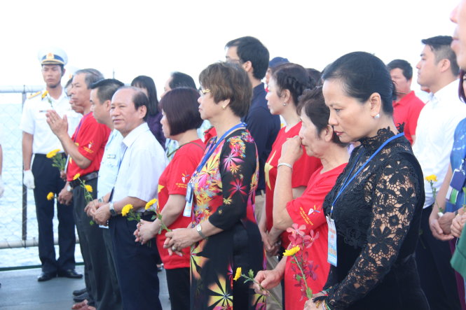 Bà Nguyễn Thị Trung Hoa (bìa phải), kiều bào tại Đức, cùng các kiều bào mỗi người một bông vạn thọ thành kính tưởng niệm các chiến sĩ nhà giàn DK1 hi sinh - Ảnh: N.T.U.