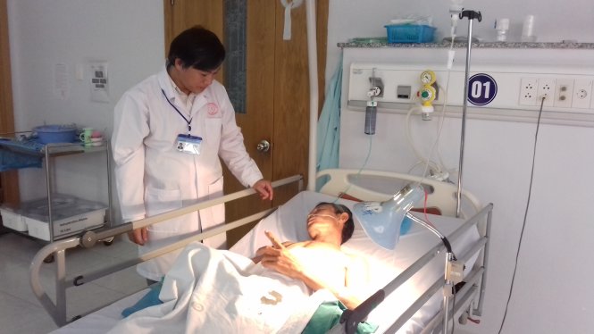 Bác sĩ La Văn Phú hỏi thăm bệnh nhân tại khu vực hậu phẫu Bệnh viện Đa khoa TP Cần Thơ - Ảnh: T. Lũy