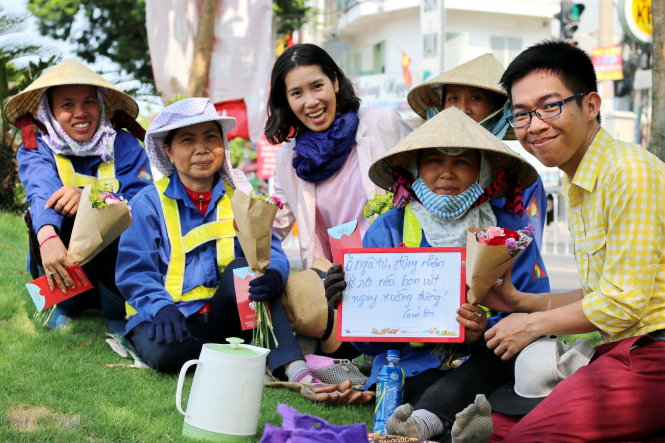 Nguyễn Hồng Việt tặng hoa cho bốn chị lao công trên đường 
Hoàng Sa (TP.HCM) chiều 30-4 - Ảnh: Ngọc Hiển