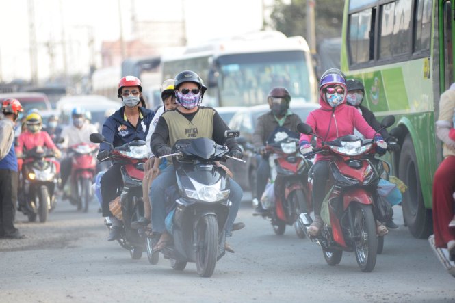 Nhiều người chen chúc nhau đi dưới nắng nóng và bụi - Ảnh: Lê Phan