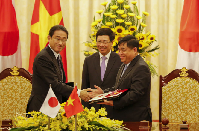 Bộ trưởng Bộ Kế hoạch và Đầu tư Nguyễn Chí Dũng (phải) và Ngoại trưởng Kishida bắt tay sau lễ ký kết - Ảnh: Việt Dũng