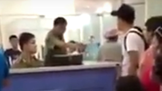 Vị khách Trung Quốc (đội mũ đen, bìa phải) cãi cọ với nhân viên an ninh cửa khẩu sân bay Cam Ranh tối 2-5 - Ảnh: chụp lại từ YouTube