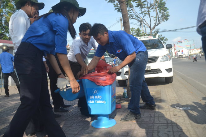 Các bạn đoàn viên thanh niên quận 7 lắp đặt các thùng đựng rác trên tuyến đường Nguyễn Thị Thập - Ảnh: Quang Phương