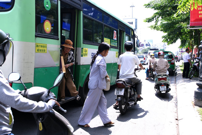 Trong khi dòng người đang lưu thông, xe buýt 04 ép vào lề đường để trả khách trên đường Hoàng Văn Thụ, Q.Tân Bình - Ảnh: Ngọc Dương