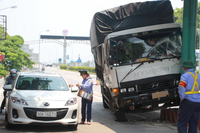 Nhân viên trạm thu phí Bến Thủy đứng bán vé cho xe ôtô qua trạm - Ảnh: Doãn Hòa