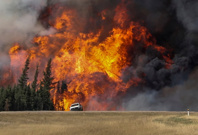 l Ảnh lớn: Lửa rừng dữ dội liếm vào một đường cao tốc gần Fort McMurray ngày 7-5 l Ảnh nhỏ (từ trái sang): Người dân sơ tán được tập trung trong một trại tạm trú thuộc tỉnh Alberta l Cảnh sát Canada đeo mặt nạ phòng khí độc trước khi tác nghiệp chống cháy rừng l Máy bay thả chất chống cháy ở Fort McMurray ngày 6-5                 Ảnh: Reuters