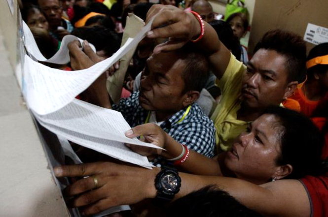Cử tri xem danh sách bầu cử ở Tondo, Manila sáng 9-5 - Ảnh: Reuters