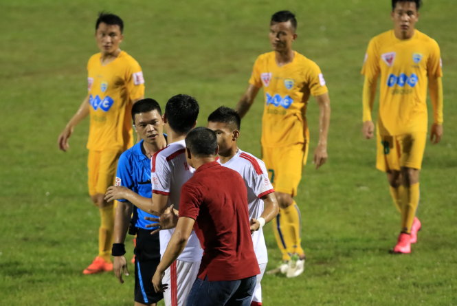 HLV Ngô Quang Trường (phải) cùng các cầu thủ SLNA phản ứng trọng tài Hà Anh Chiến - Ảnh: Nam Khánh