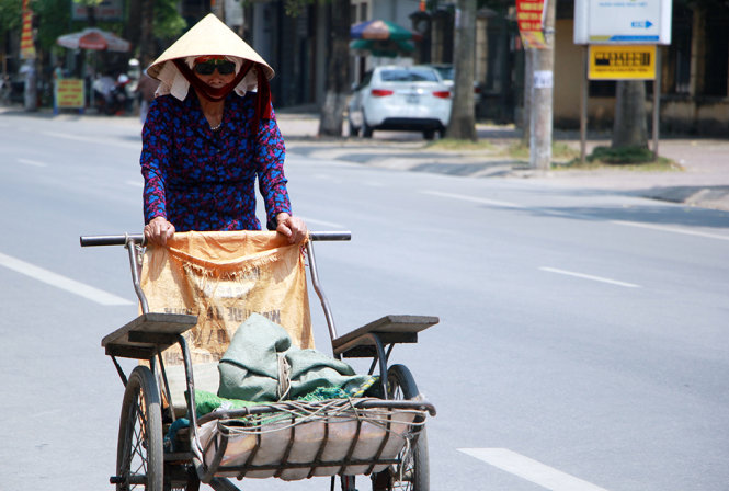 Một cụ bà đạp xích lô trên phố Nguyễn Thị Minh Khai, TP Vinh trưa 9-5 không một bóng người qua lại - Ảnh: Doãn Hòa