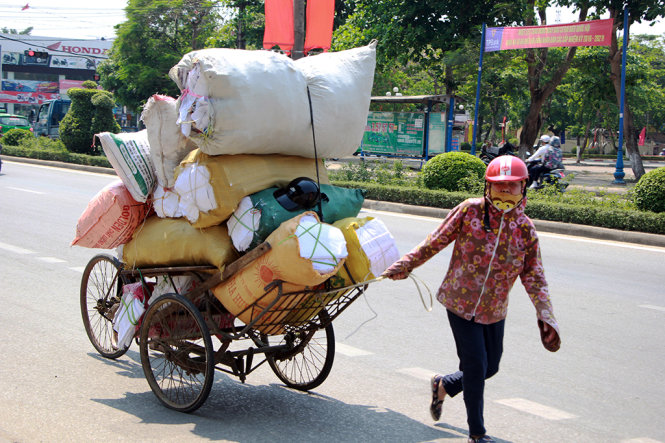 Hai phụ nữ mệt nhọc kéo xe hàng trên đường Trần Phú, TP Vinh dưới cái nắng hầm hập - Ảnh: Doãn Hòa