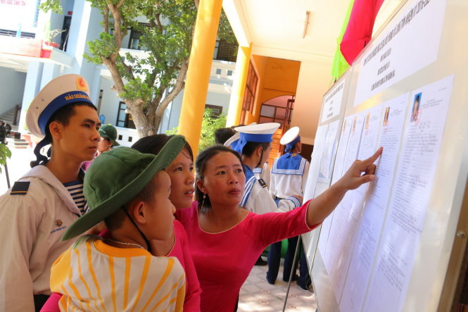 Các chiến sĩ và người dân xã đảo Sinh Tồn (huyện đảo Trường Sa, Khánh Hòa) xem danh sách ứng cử viên đại biểu Quốc hội, HĐND các cấp - Ảnh: Tiến Long