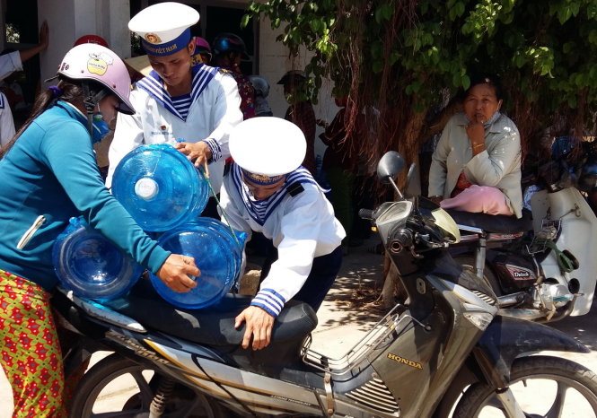 Các học viên của trường Trung cấp Kĩ thuật Hải quân giúp bà con vận chuyển nước - Ảnh: Ngọc Loan