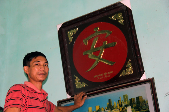 Ông Nguyễn Văn Đức và chữ “an” do Bảo tàng Bắc Ninh tặng - Ảnh: Thái Lộc