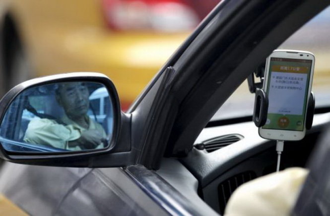 Một tài xế xe hơi chờ khách gọi qua ứng dụng gọi xe Didi Chuxing tại Bắc Kinh, Trung Quốc - Ảnh: Reuters